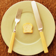 Tiny toast on big plate with fork and knife
